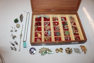 A box of costume jewellery to include brooches, pe