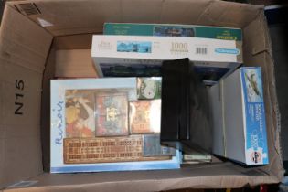 A box of various jigsaw puzzles and games