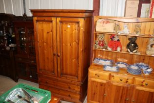 A pine two door wardrobe fitted two drawers below