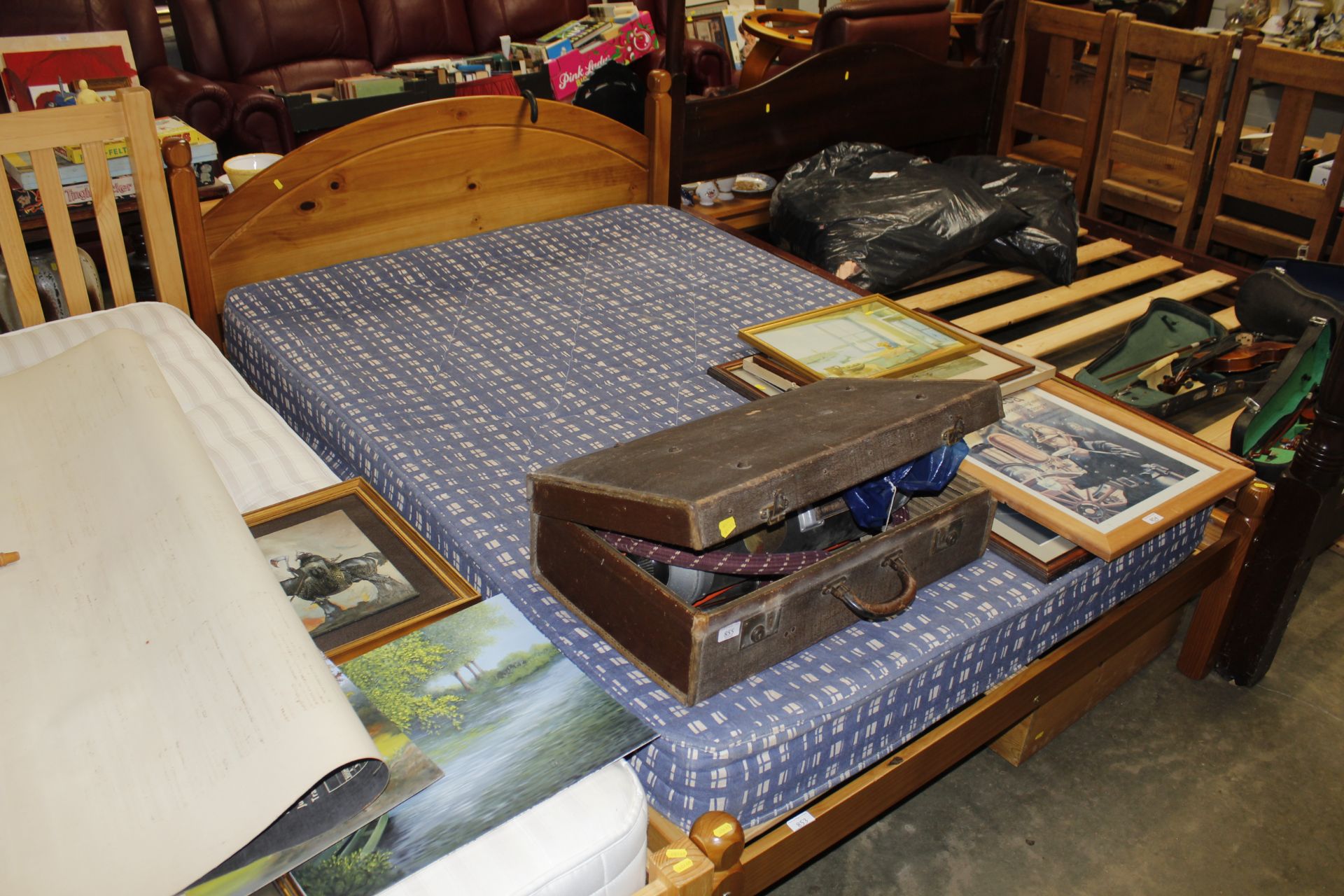 A pine double bed frame with mattress and four und