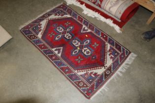 An approx. 4'2" x 2'5" red and blue patterned rug