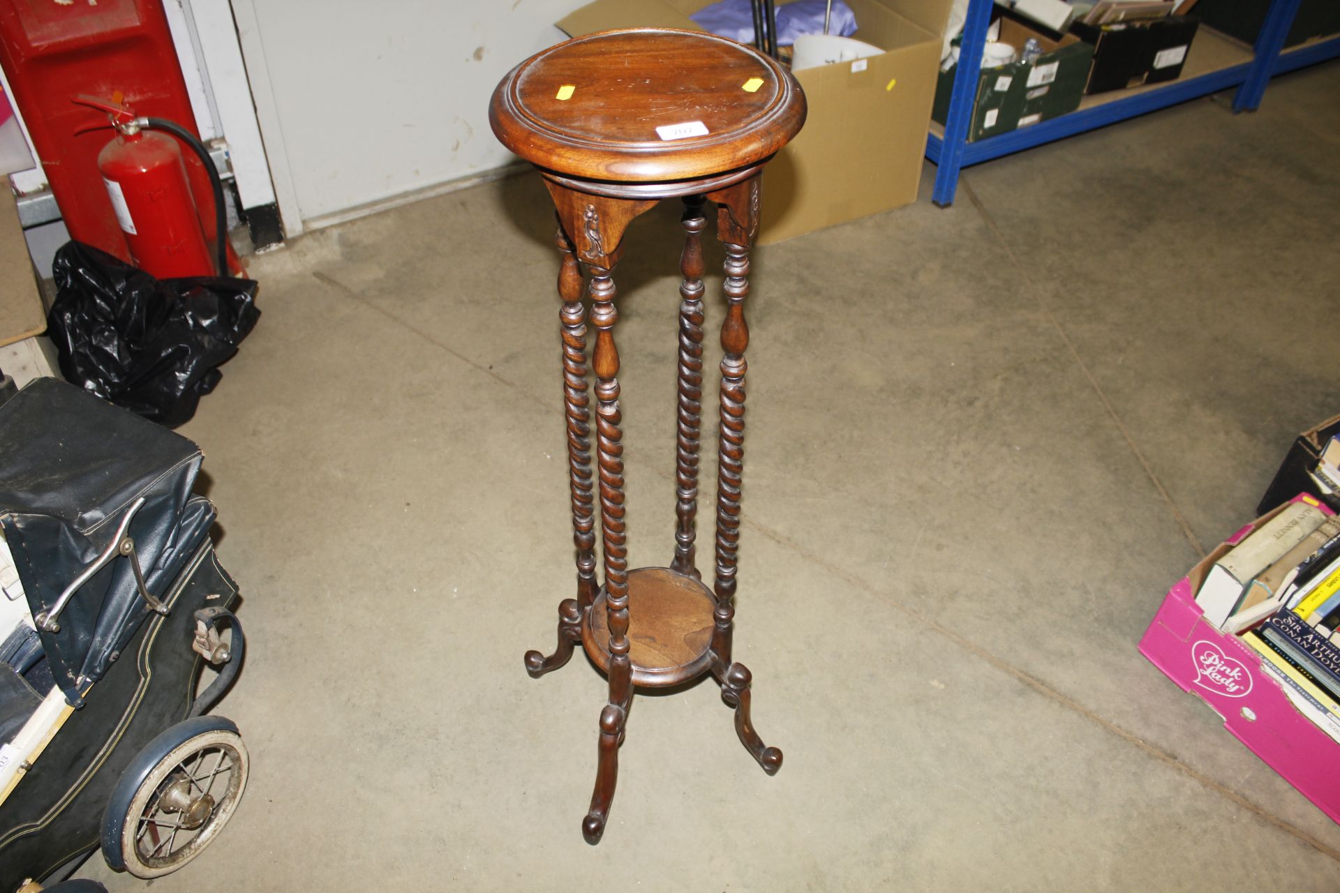 A mahogany plant stand raised on spiral twist supp