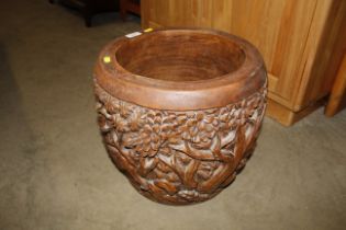 A carved hardwood jardinière decorated with elepha