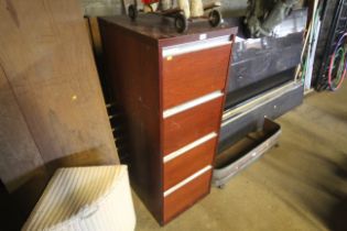 A wooden four drawer filing cabinet