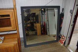 A large framed and bevelled edged wall mirror