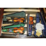 Three violins with bows and a violin case