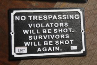 A painted cast iron sign "No Trespassing, Violator