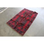 An approx. 5'2" x 3'1" Balochi patterned rug