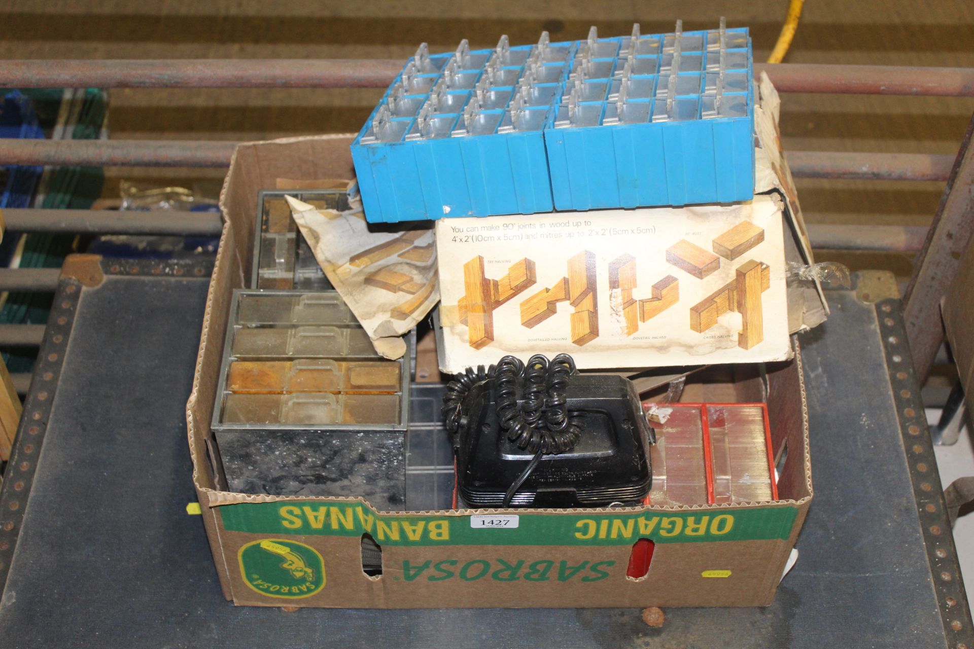 A box containing various multi-drawer storage rack