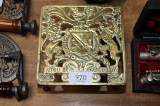 A antique brass ornate trivet decorated with Briti