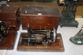 A hand operated sewing machine in fitted wooden ca