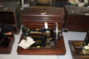 A Singer hand sewing machine in fitted wooden case