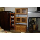 An ercol style wall unit fitted with cupboard belo