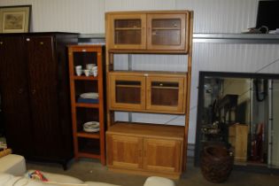 An ercol style wall unit fitted with cupboard belo