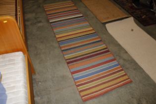 An approx. 7'11" x 2'4" striped patterned rug