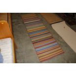 An approx. 7'11" x 2'4" striped patterned rug