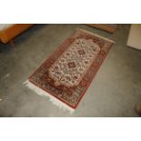 An approx. 5'3" x 2'6" floral patterned wool rug