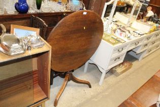 An early 19th Century oak snap top table raised on tripod base