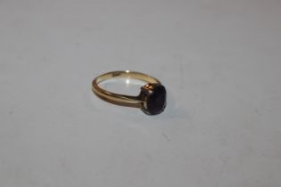 An 18ct gold ring set with amethyst coloured stone