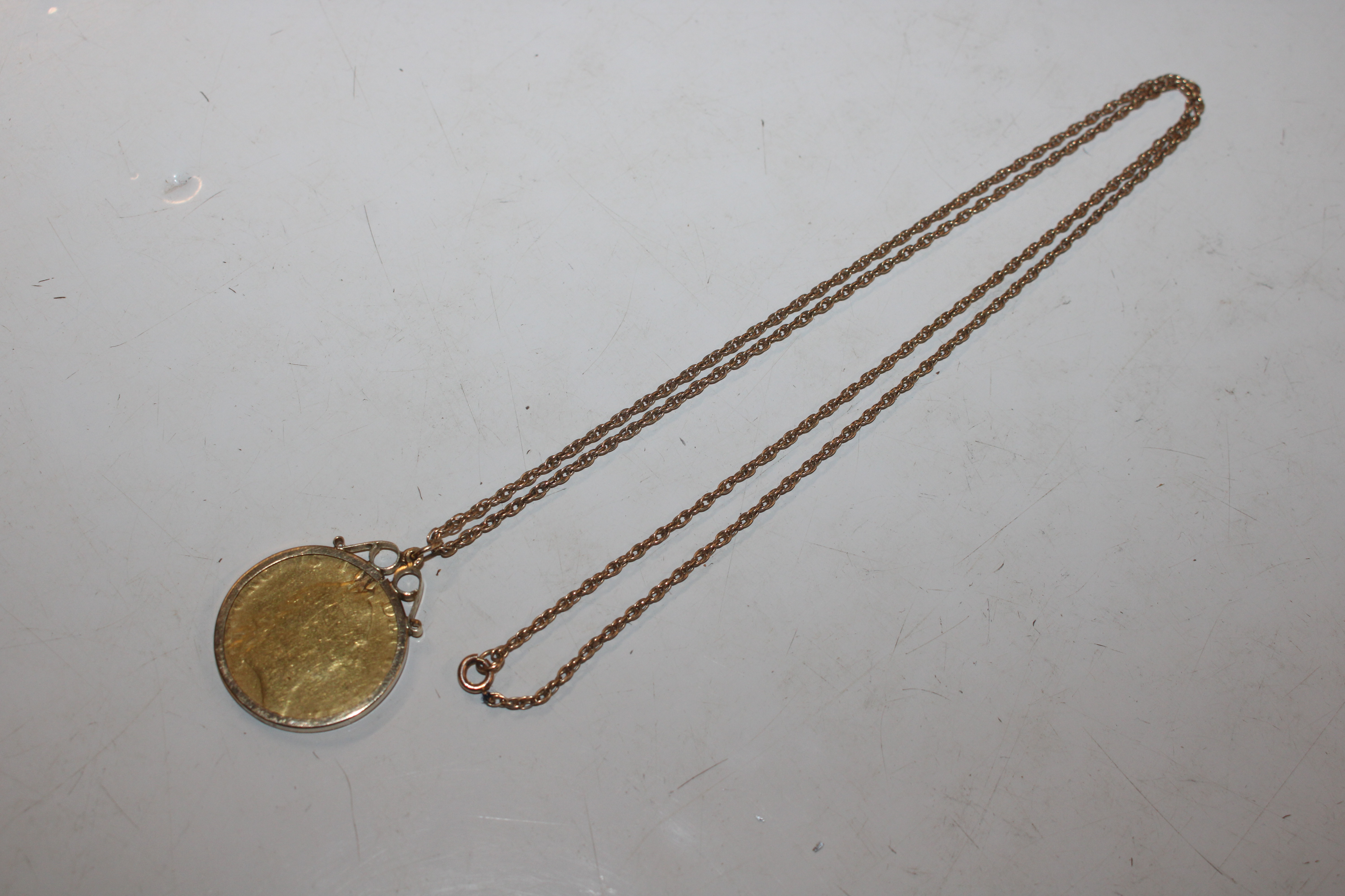 A Guinea contained in 9ct gold mount and hung to y