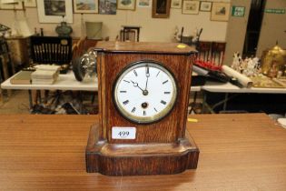 An oak cased single hole mantel clock