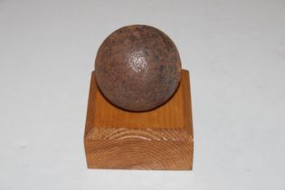 A canon ball on a wooden stand