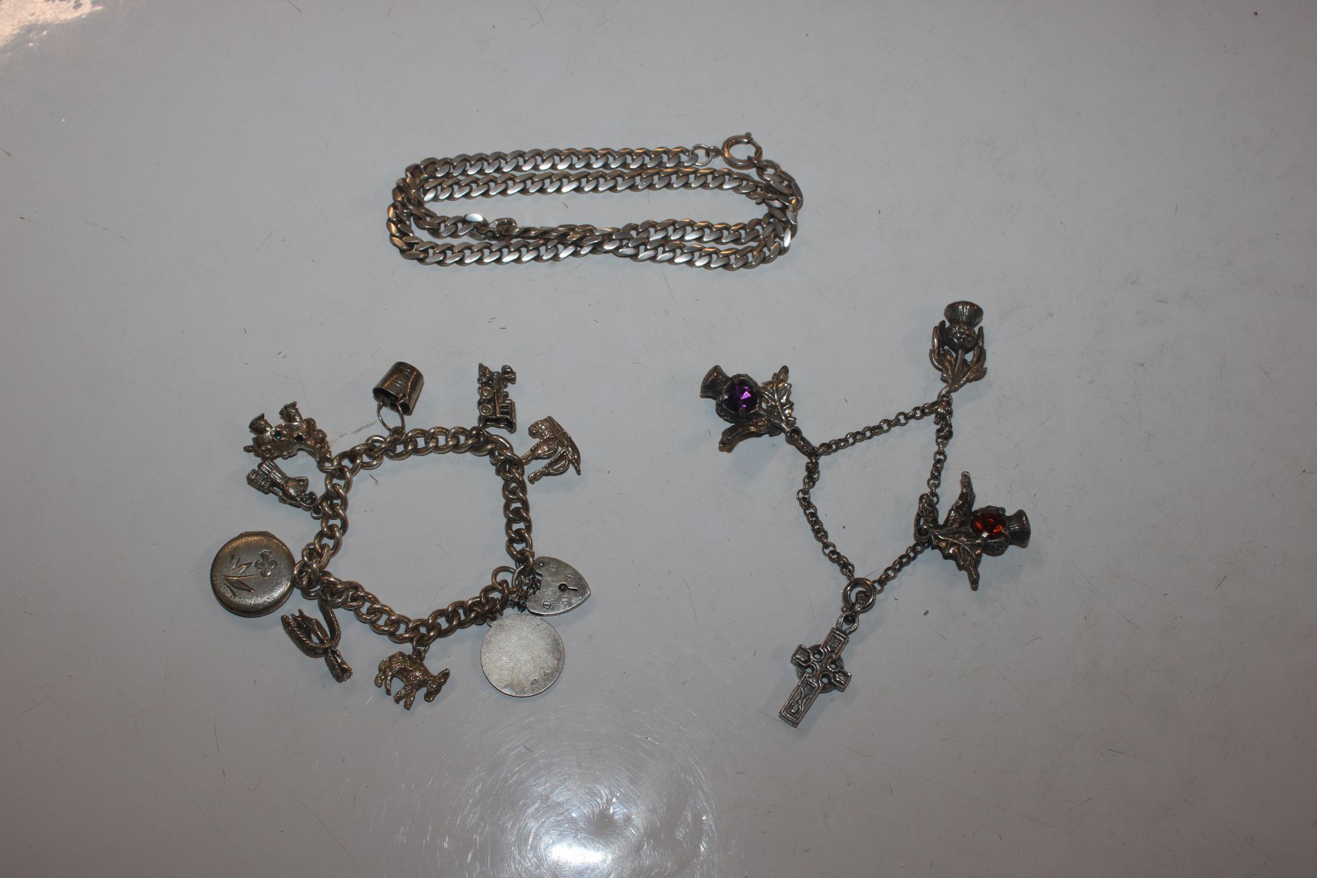 A silver charm bracelet; another charm bracelet an