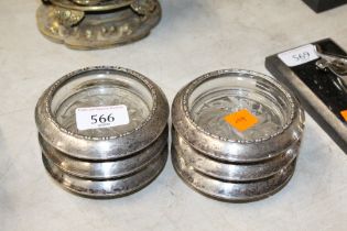 A set of six white metal and glass coasters