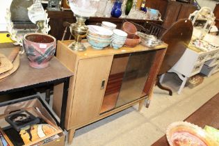 A teak bookcase with sliding glass doors