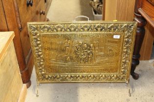 A brass embossed fire screen decorated with interi