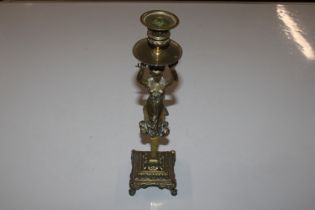 An ornate brass candlestick with female decoration