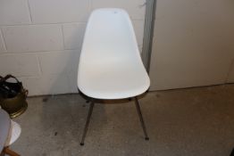 A Vitra Eames white plastic chair