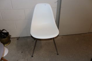 A Vitra Eames white plastic chair
