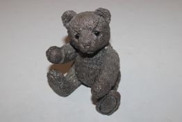 A filled silver model of a teddy bear