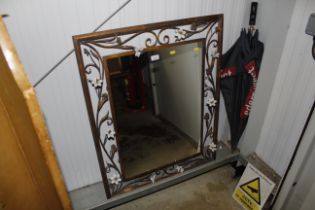 A decorative gilded floral applied wall mirror