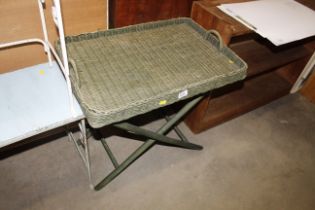 A wicker tray top side table on folding stand