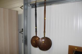 Two antique copper warming pans with turned wooden