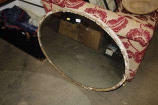 An oval gilt and painted wall mirror