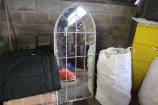 A large metal framed arched gothic style garden mirror