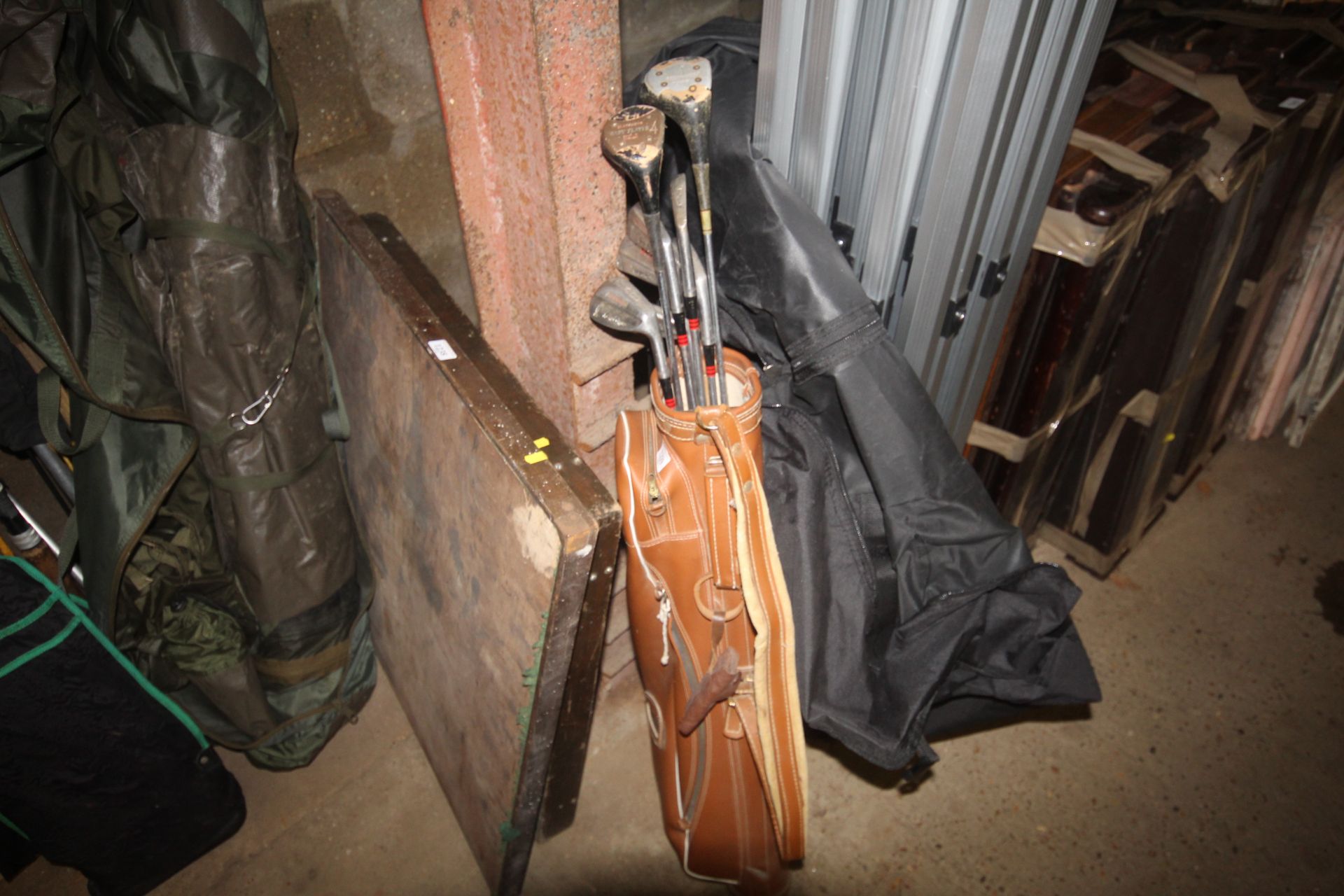 A vintage leather golf bag and quantity of clubs t