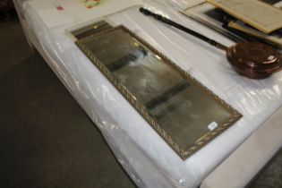 A gilt framed wall mirror and a cream and gilt fra