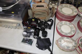 An Olympus Trip camera, a Cannon digital camera, various other cameras and lenses plus a carry bag