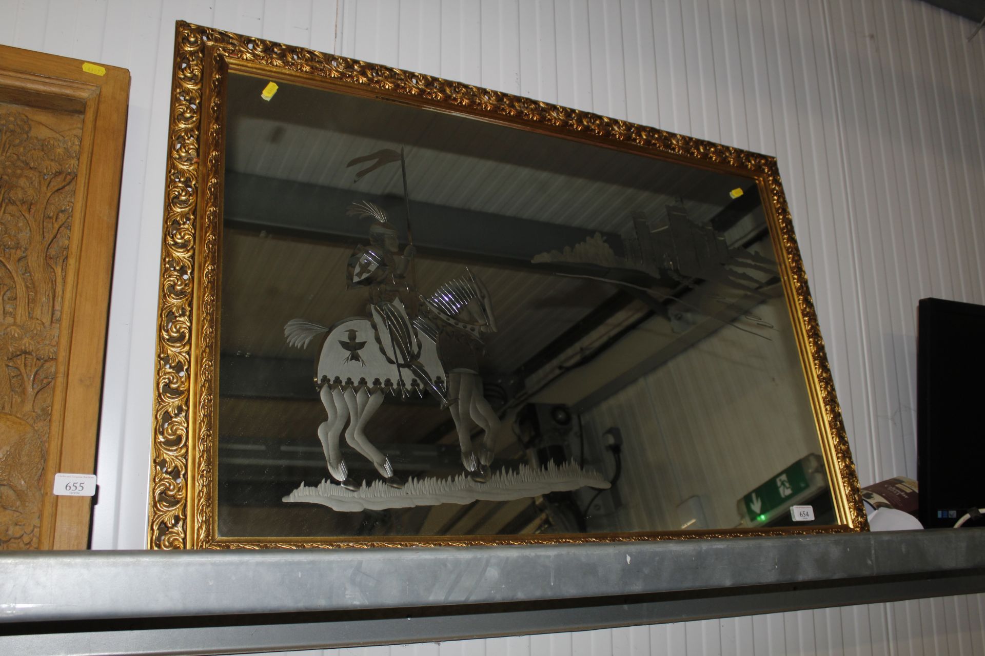 A decorative gilt frame wall mirror with etched de