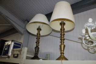 A pair of brass table lamps with shades