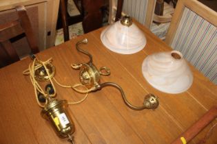 A rise and fall brass light fitting with two glass