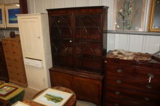 A Georgian walnut and mahogany bookcase raised on