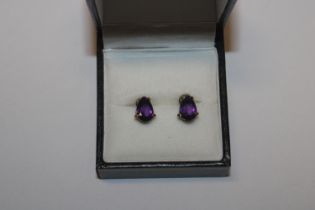 a pair of ear-rings with amethyst coloured stones