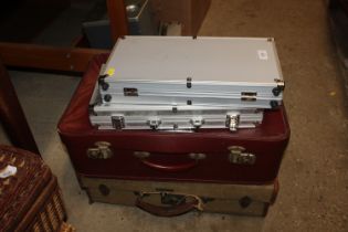 A canvas suitcase; one other suitcase and two case