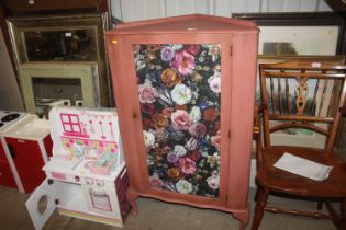 A floral decorated corner cabinet raised on squat