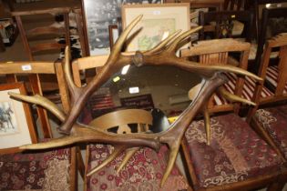 A wall mirror decorated with faux antlers